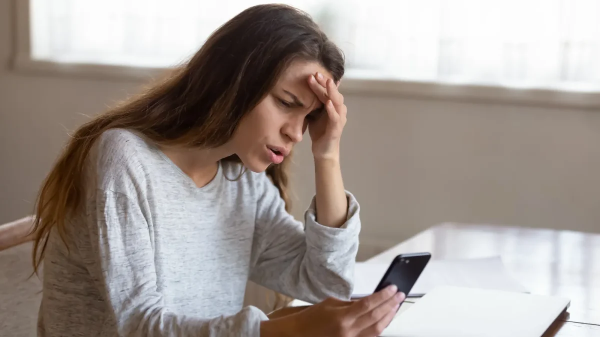Femme agacée devant son téléphone qui refuse son mot de passe de messagerie