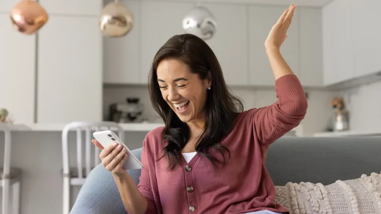 Femme ravie devant son smartphone après avoir configuré sa boîte mail